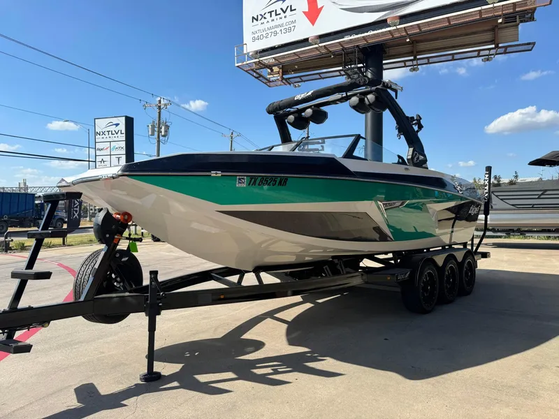 Slide: The Image of 2023 Tigé 24RZX boat on trailer under clear blue sky. - 8