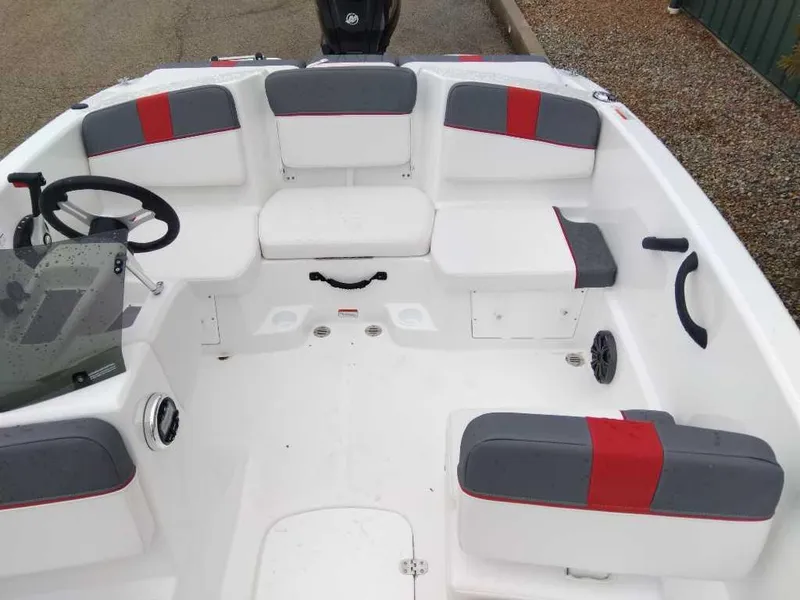 Slide: The Image of 2025 Tahoe T16 boat interior with gray and red seating, steering wheel, and controls. - 2