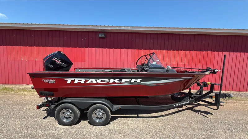 The Image of 2025 Tracker Targa V-19 Combo boat on trailer, red exterior, parked by red building. - 0