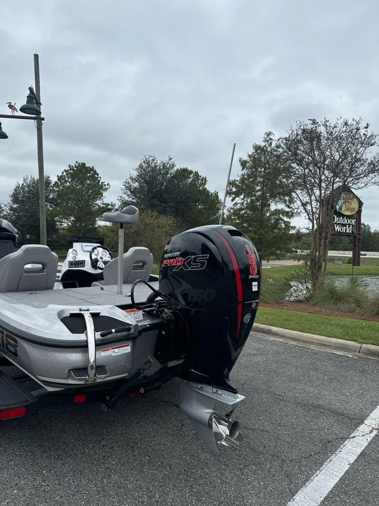 Slide: The Image of 2025 Nitro Z18 boat with powerful engine parked outdoors near trees. - 1