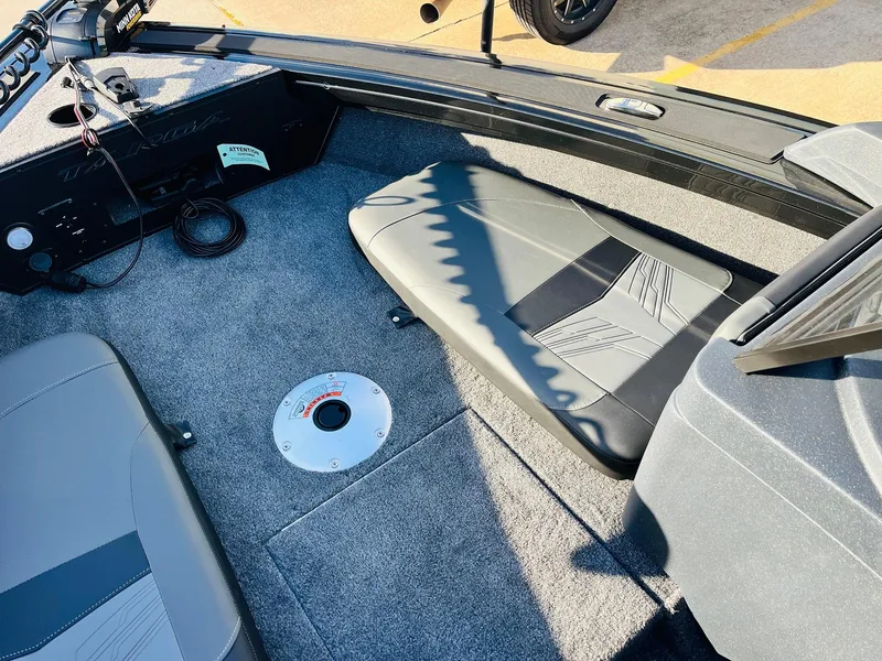 Slide: The Image of 2025 Tracker Targa V-18 Combo boat interior with gray seating and carpeted floor. - 12