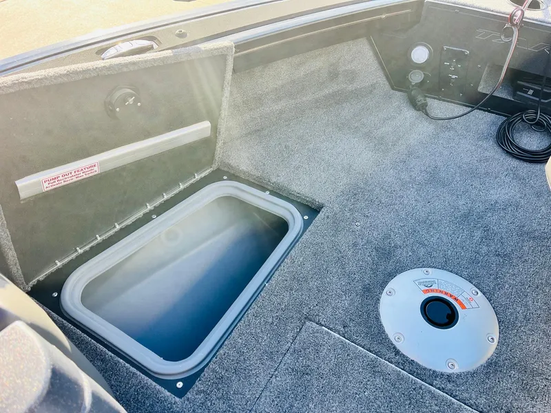 Slide: The Image of 2025 Tracker Targa V-18 Combo boat interior with storage compartment and carpeted flooring. - 15