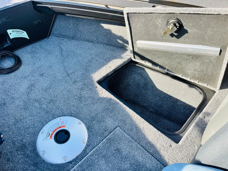 Slide: The Image of 2025 Tracker Targa V-18 Combo boat interior with storage compartment and carpeted flooring. - 16