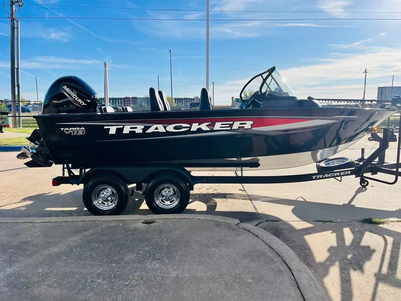 Slide: The Image of 2025 Tracker Targa V-18 Combo boat on trailer, parked outdoors under clear sky. - 4