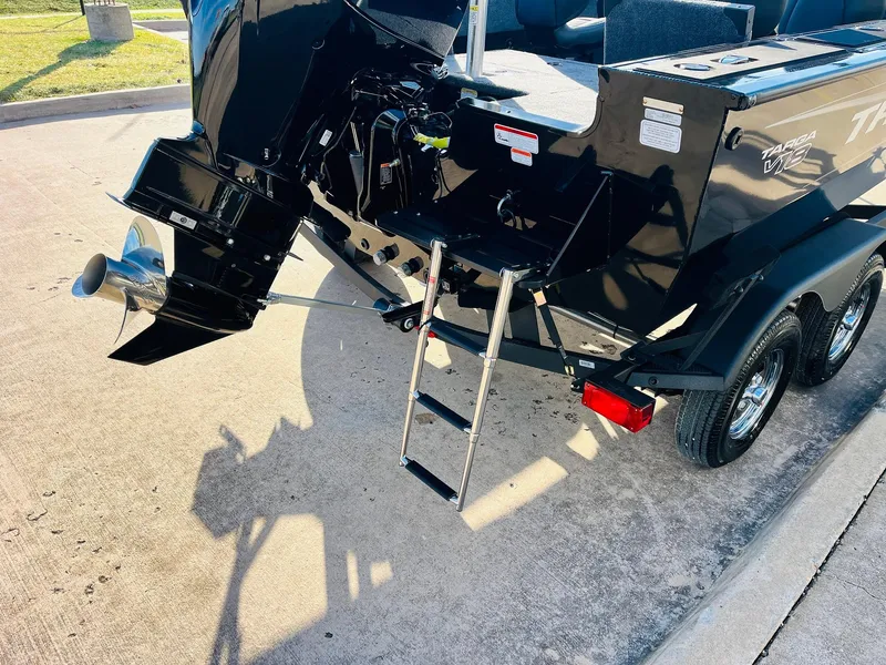 Slide: The Image of 2025 Tracker Targa V-18 Combo boat with outboard motor and ladder on trailer. - 8