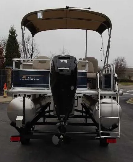 Slide: The Image of 2025 Sun Tracker Bass Buggy 18 DLX pontoon boat with 75 HP engine, rear view. - 2