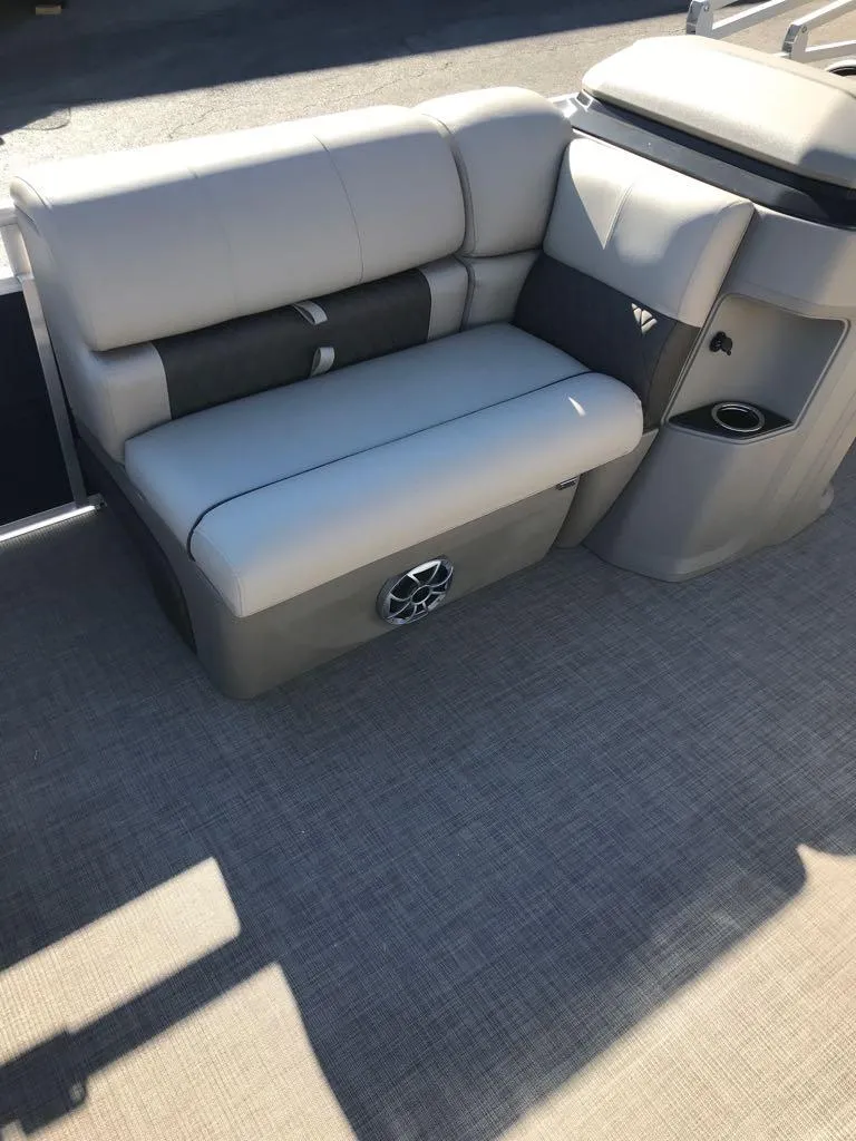 Slide: The Image of 2025 Sun Tracker Fishin' Barge 22 DLX interior seating with speaker and storage. - 11