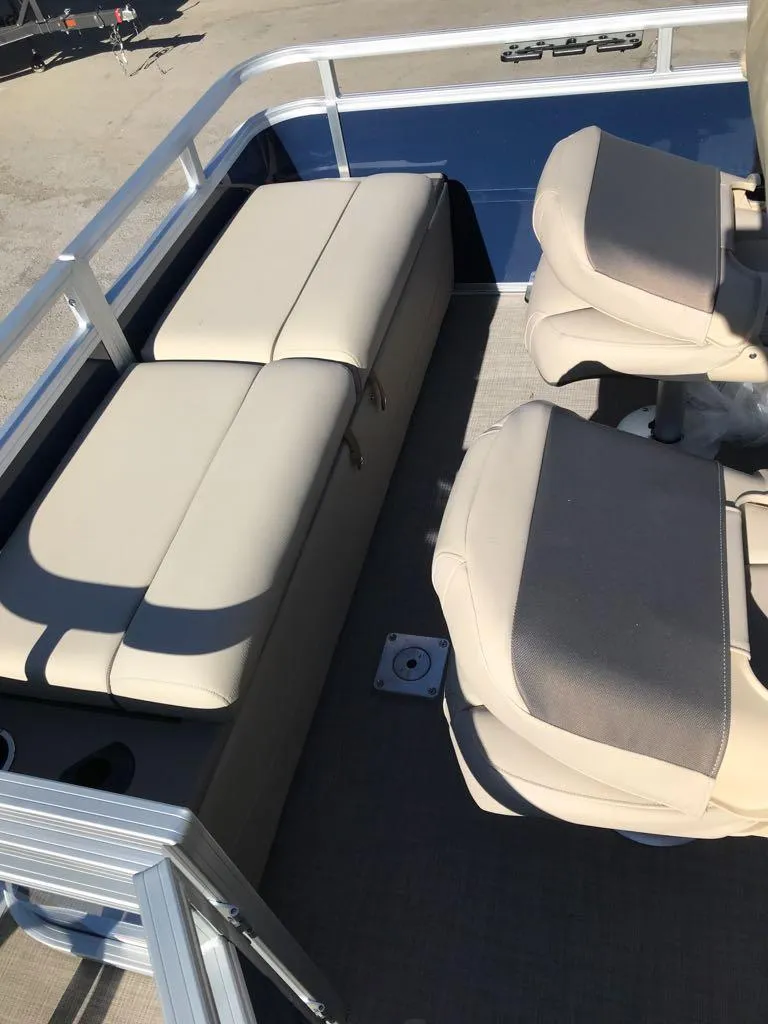 Slide: The Image of 2025 Sun Tracker Fishin' Barge 22 DLX interior seating area with beige cushions. - 13