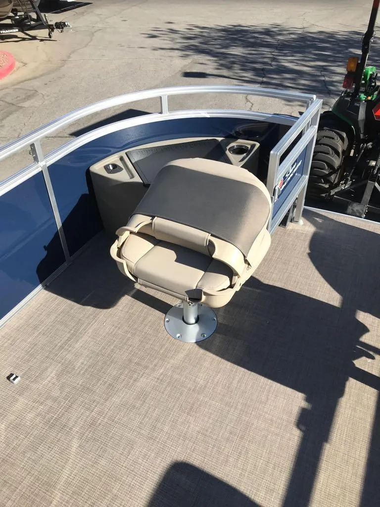 Slide: The Image of 2025 Sun Tracker Fishin' Barge 22 DLX with beige seating and blue railing. - 14