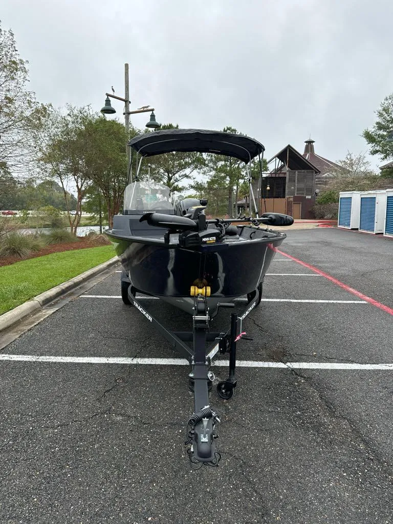 Slide: The Image of 2025 Tracker Pro Guide V-16 SC boat parked outdoors on a cloudy day. - 3
