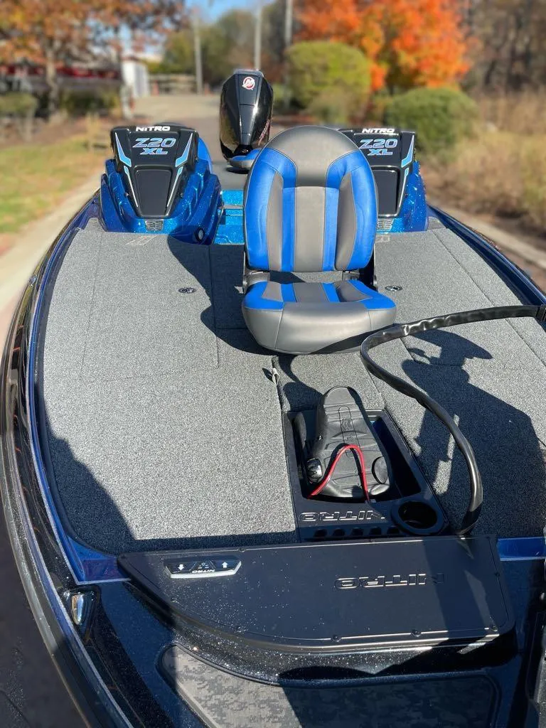 Slide: The Image of 2025 Nitro Z20 XL boat with blue and gray seating, outdoor setting. - 2