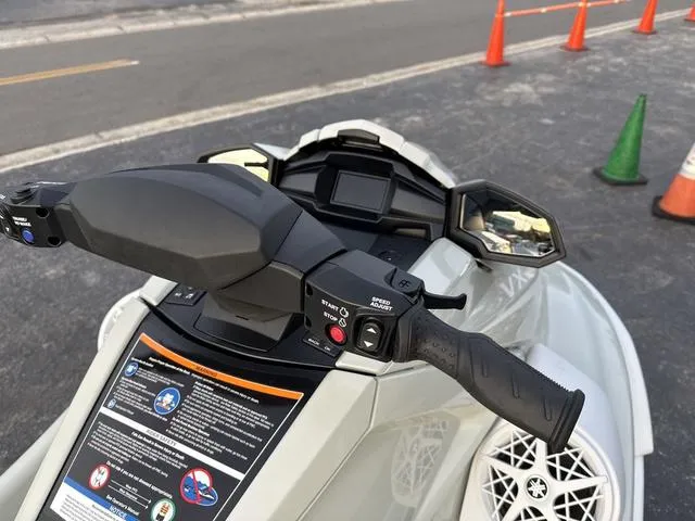 Slide: The Image of 2025 Yamaha Marine Waverunner VX handlebars and dashboard, parked near traffic cones. - 8