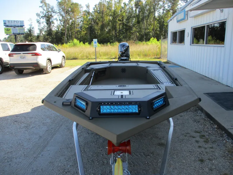 Slide: The Image of 2025 Avid 16 Commander boat with blue LED lights, parked outdoors. - 2