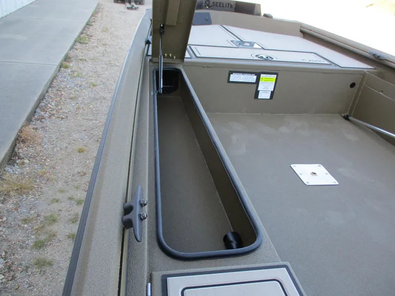 Slide: The Image of Avid 16 Commander 2025 boat storage compartment, open lid, beige interior. - 5