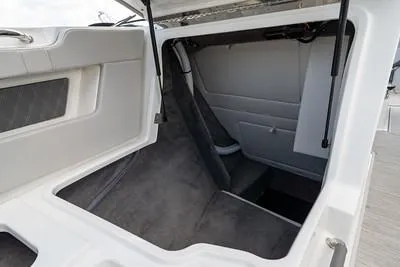 Slide: The Image of 2025 Sea Ray SLX 310 Outboard storage compartment with open hatch, showcasing spacious interior. - 15