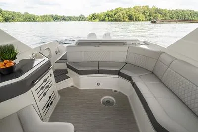 Slide: The Image of 2025 Sea Ray SLX 310 Outboard interior with luxurious seating and lake view. - 9