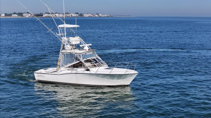 The Image of 1999 Carolina Classic 28 Express boat cruising on open water. - 0