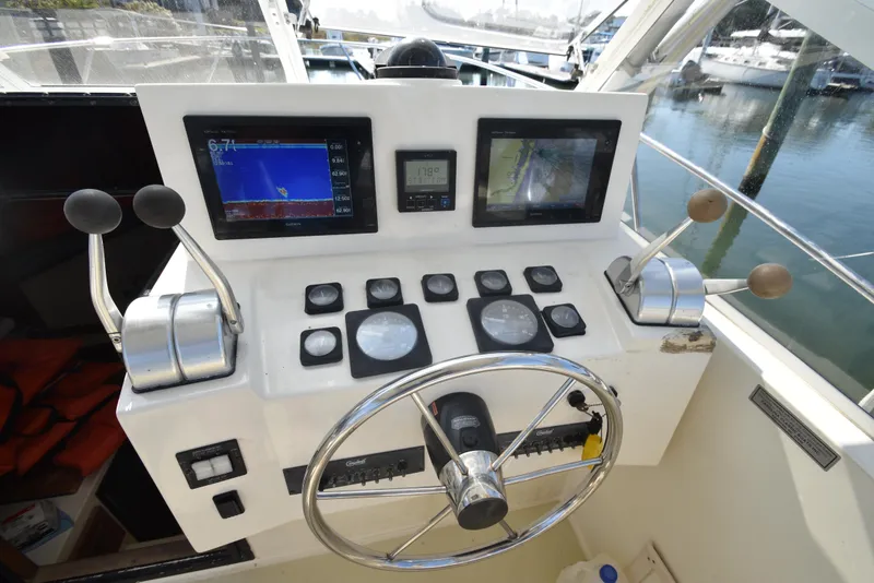 Slide: The Image of 1999 Carolina Classic 28 Express helm with navigation screens and controls. - 11