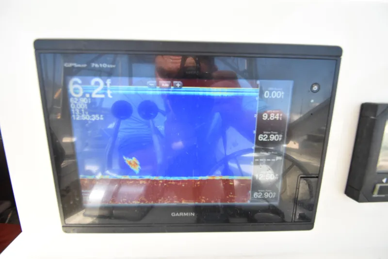 Slide: The Image of Garmin fishfinder display on 1999 Carolina Classic 28 Express boat, showing depth and water temperature. - 12