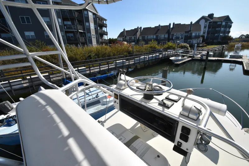 Slide: The Image of 1999 Carolina Classic 28 Express boat docked near waterfront homes. - 16