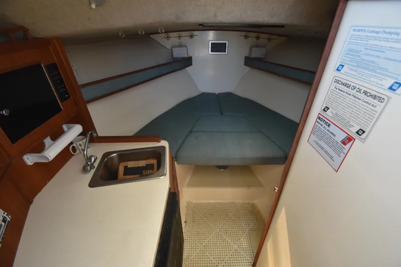 Slide: The Image of Interior of 1999 Carolina Classic 28 Express boat with kitchenette and sleeping area. - 17