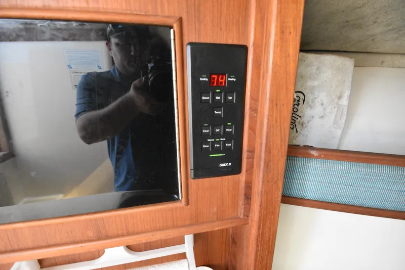 Slide: The Image of 1999 Carolina Classic 28 Express cabin with digital control panel and wooden interior. - 21