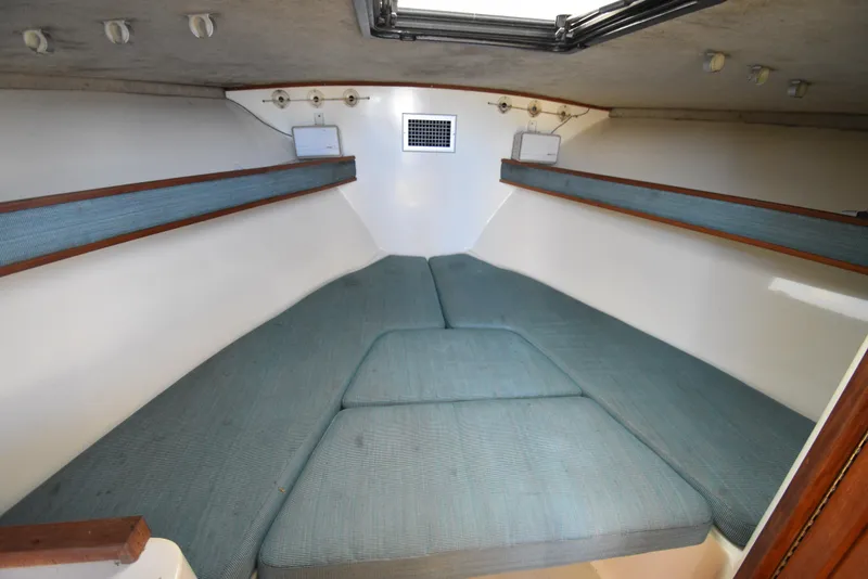Slide: The Image of Interior cabin of 1999 Carolina Classic 28 Express with blue cushions and wooden trim. - 22