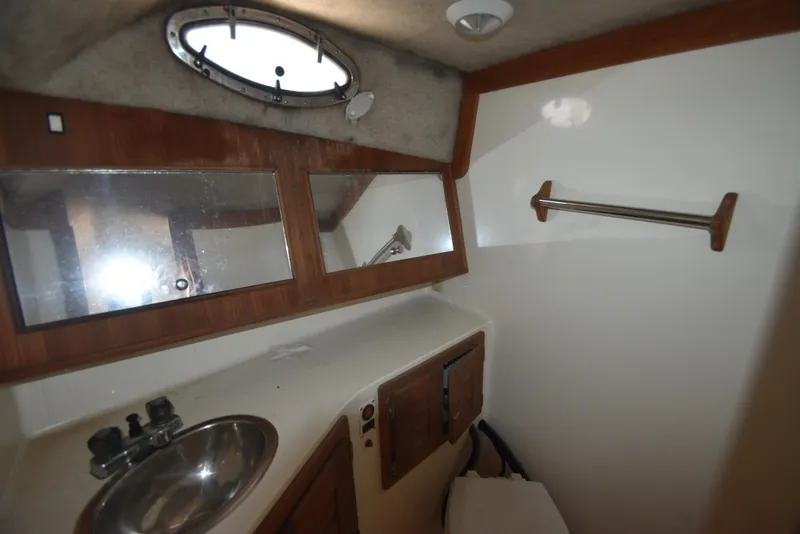 Slide: The Image of 1999 Carolina Classic 28 Express boat bathroom with sink, mirror, and towel rack. - 23