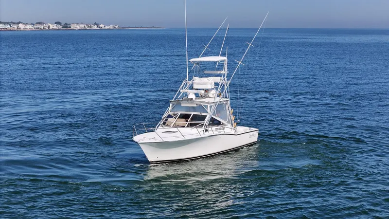 Slide: The Image of 1999 Carolina Classic 28 Express boat cruising on open water. - 4