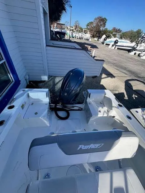 Slide: The Image of 2025 Parker 21 SE CC boat with outboard motor, docked near a marina. - 12