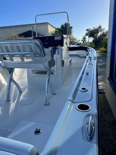 Slide: The Image of 2025 Parker 21 SE CC boat interior with seating and console, docked outdoors. - 4