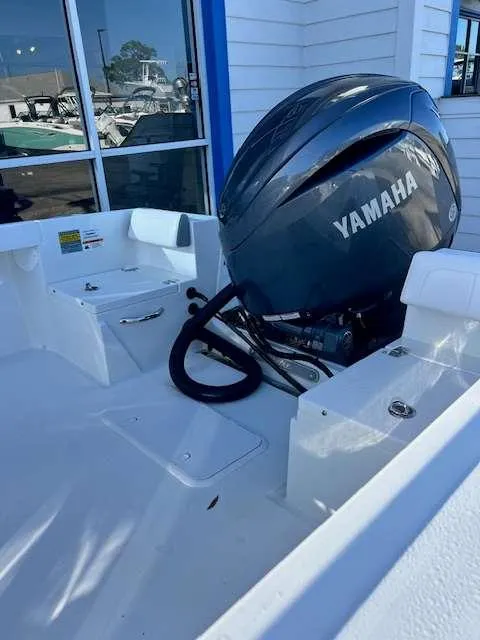 Slide: The Image of 2025 Parker 21 SE CC boat with Yamaha outboard motor, docked near a building. - 5