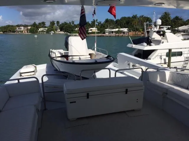 Slide: The Image of 1998 Hatteras 74 Sport Deck yacht with tender, docked in scenic marina. - 26