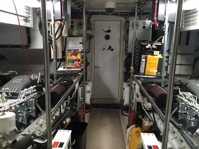 Slide: The Image of Engine room of 1998 Hatteras 74 Sport Deck yacht, featuring dual engines and equipment. - 22