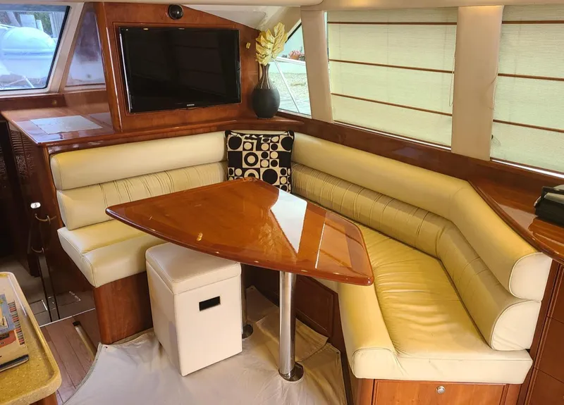 Slide: The Image of Luxurious interior of 2009 Riviera 47 Enclosed Flybridge with leather seating and wooden table. - 34