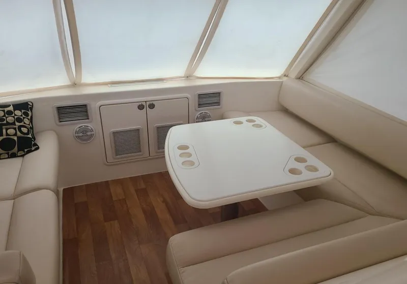 Slide: The Image of Interior of 2009 Riviera 47 Enclosed Flybridge with beige seating and wooden flooring. - 42