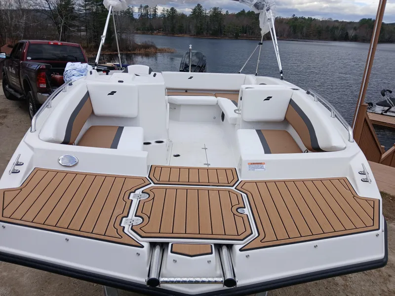 Slide: The Image of 2025 Starcraft SVX 171 OB boat with spacious seating and sleek design by a lake. - 2