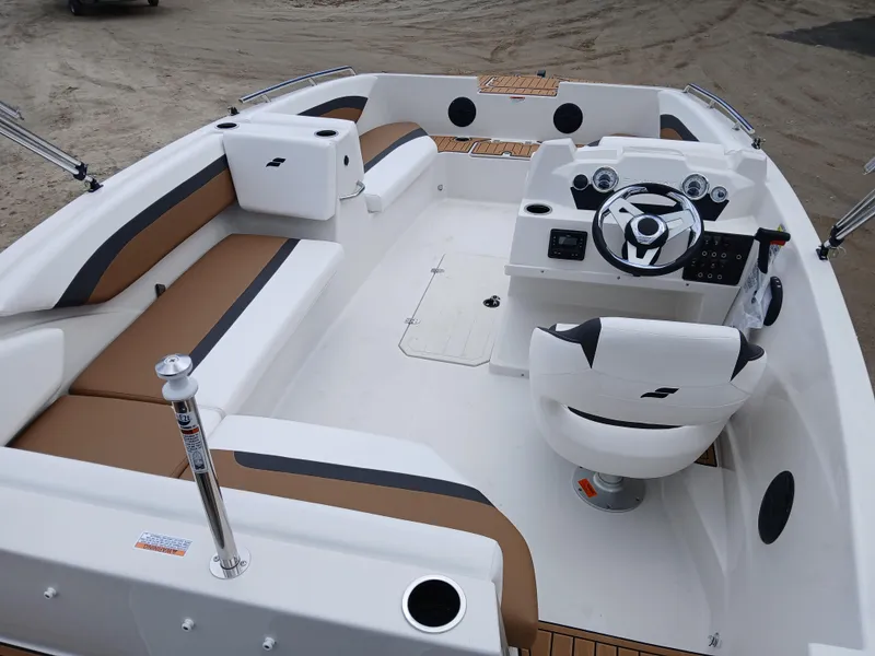 Slide: The Image of 2025 Starcraft SVX 171 OB boat interior with white and brown seating, steering console. - 6