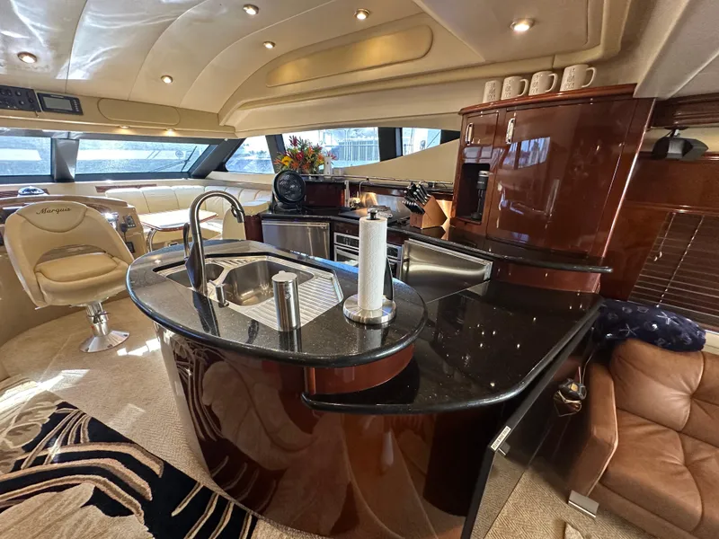 Slide: The Image of Luxurious 2004 Marquis 59 yacht interior with modern kitchen and elegant seating. - 13