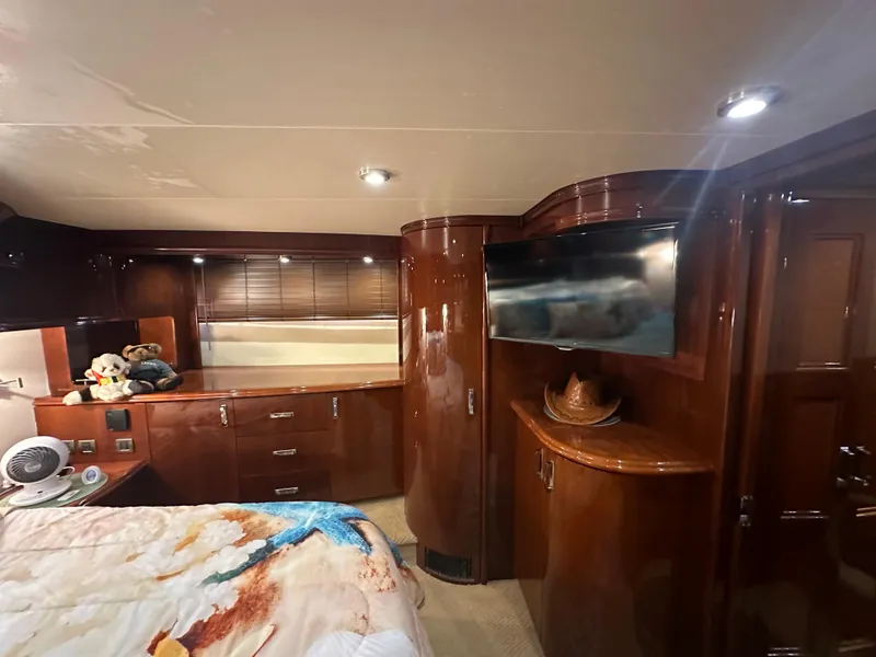 Slide: The Image of Luxurious 2004 Marquis 59 yacht bedroom with wood cabinetry and modern amenities. - 19