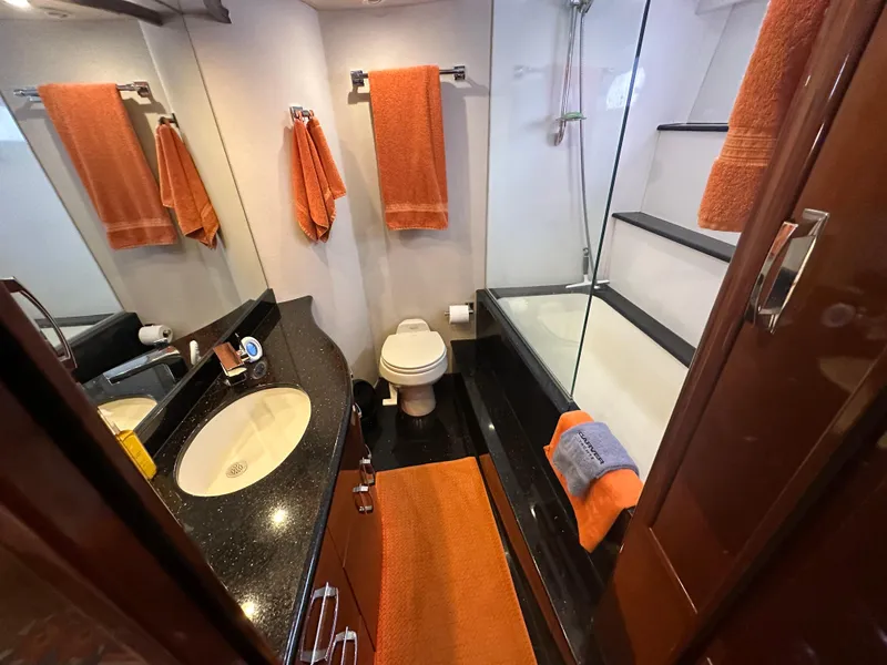 Slide: The Image of Luxurious 2004 Marquis 59 yacht bathroom with orange accents and modern fixtures. - 21