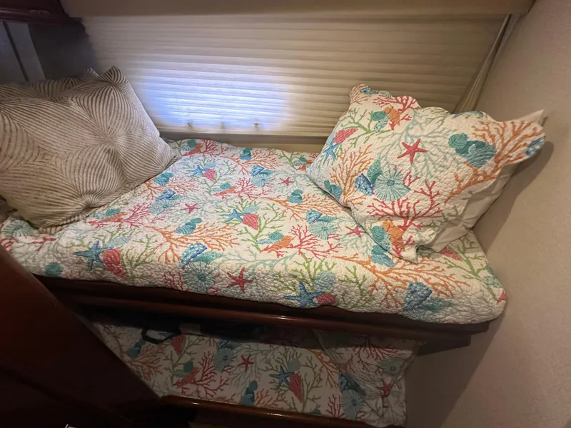 Slide: The Image of Cozy bed in 2004 Marquis 59 yacht with colorful marine-themed bedding. - 22