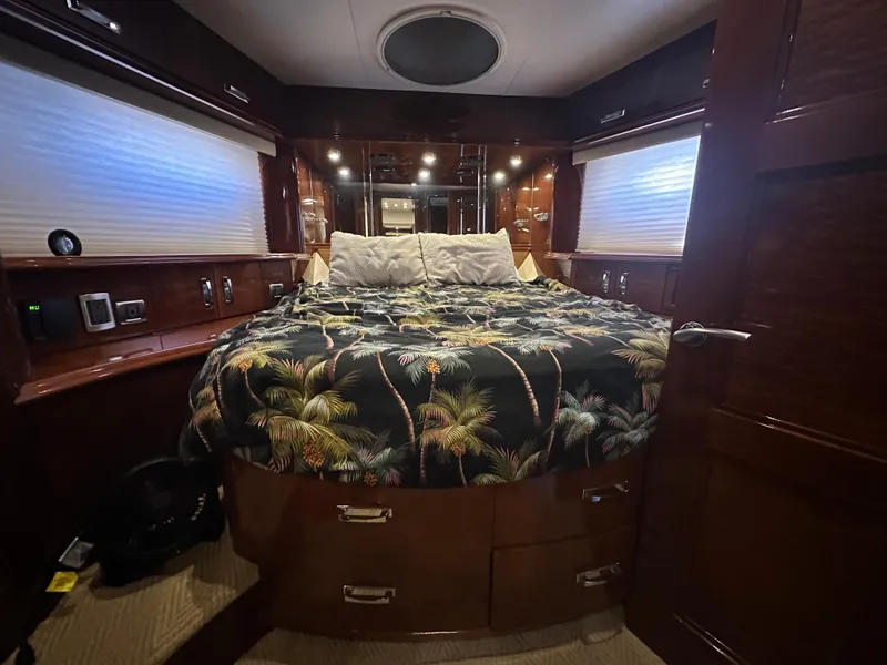 Slide: The Image of Luxurious 2004 Marquis 59 yacht bedroom with tropical-themed bedding and elegant wood finishes. - 23