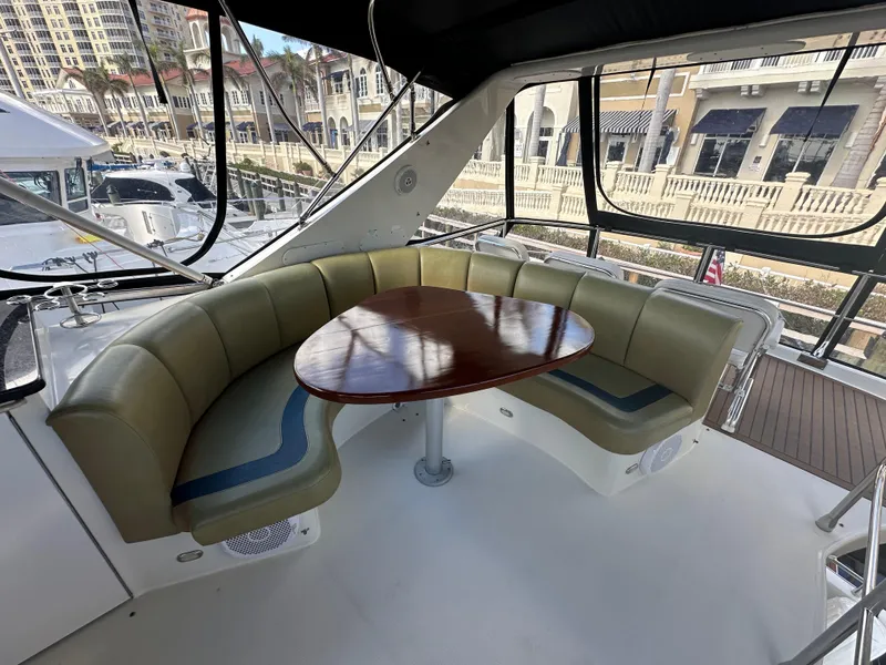 Slide: The Image of Luxurious 2004 Marquis 59 yacht interior with curved seating and wooden table. - 26