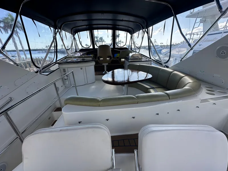 Slide: The Image of Luxurious 2004 Marquis 59 yacht interior with seating and table, docked at marina. - 27