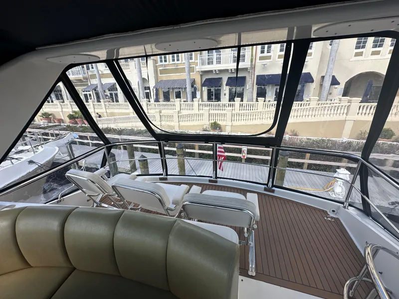Slide: The Image of Interior view of 2004 Marquis 59 yacht with seating and marina backdrop. - 29