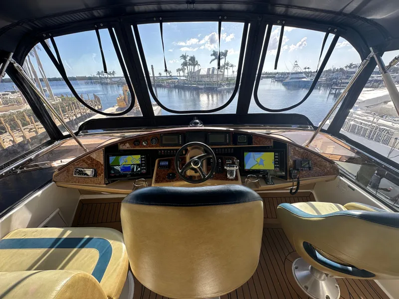 Slide: The Image of Interior view of 2004 Marquis 59 yacht cockpit with navigation screens and waterfront scenery. - 31