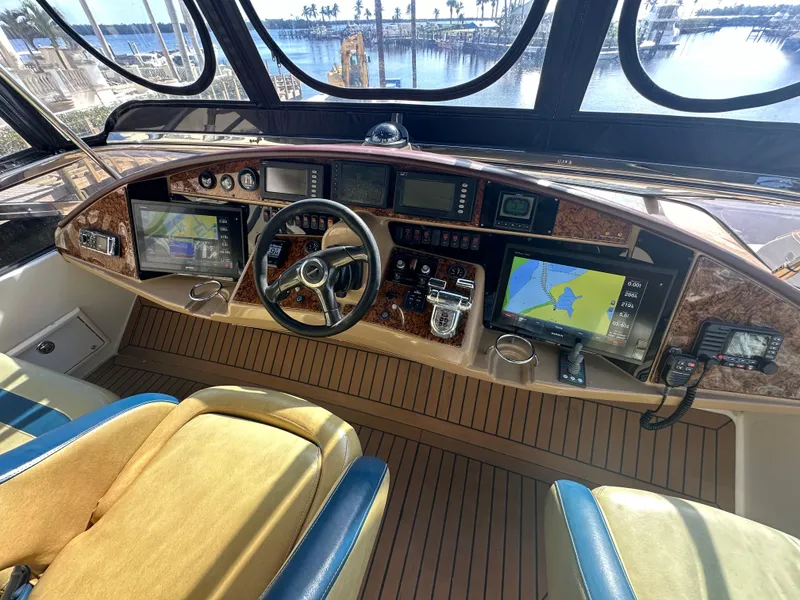 Slide: The Image of Luxurious 2004 Marquis 59 yacht helm with advanced navigation systems and elegant wood finish. - 32