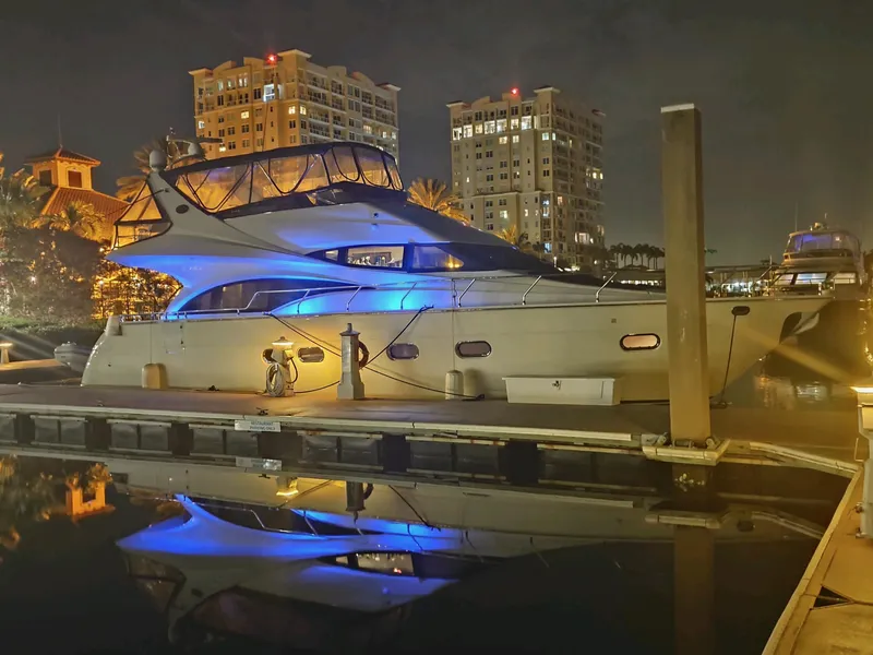 Slide: The Image of Luxurious 2004 Marquis 59 yacht docked at night, illuminated by blue lights. - 5