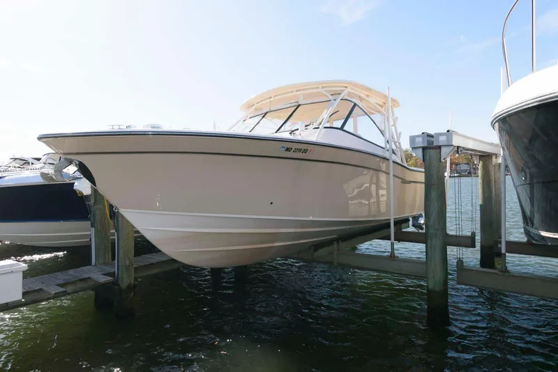 Slide: The Image of 2015 Grady-White Freedom 335 boat docked on water under clear sky. - 1